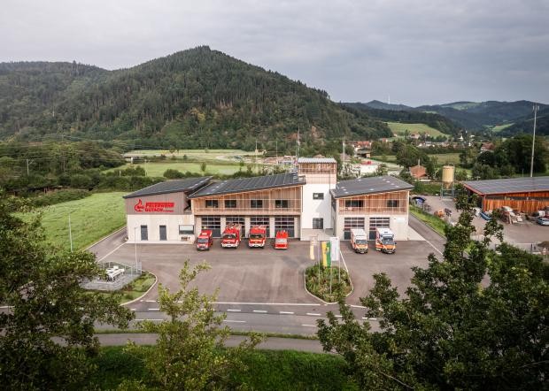 Blick über das Feuerwehrgerätehaus, Berge, im Vordergrund Bäume